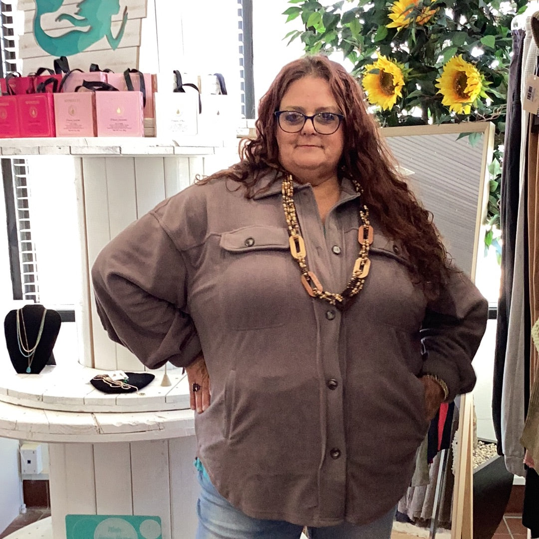cool gray toned brown button up jacket with collar, metal button close pockets on both sides on the chest area. Two slit pockets are on the front bottom panels of the jacket. Available in sizes 1X-3X. 95% Polyester, 5% Spandex. Brand: Sweet Lovely by Jen